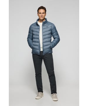 Unsere Ultralight-Herrenjacke Chase zeichnet sich durch ein modernes und funktionelles Design aus. Die leichte Steppung wärmt, ohne den Komfort zu beeinträchtigen. Sie ist ohne Kapuze und mit Reißverschluss ausgestattet und verfügt über zwei Seitentaschen und eine Innentasche mit Reißverschluss für zusätzliche Funktionalität. Das Kleidungsstück ist wasserabweisend, jedoch nicht völlig wasserdicht, was es zu einer perfekten Wahl für eine Vielzahl von Wetterbedingungen macht. Unser neuer gummierter, farblich angepasster Rigby Go Aufnäher auf der Brust, die schrägen Einsätze und das Futter in Kontrastfarbe machen dieses Kleidungsstück zu einem modernen Klassiker.