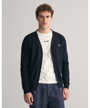 This durable and sophisticated cardigan from GANT is crafted in 100% cotton. Cut for a regular fit, it features a V-neck, knitted pockets, branded corozo buttons and ribbed detailing at the hem and cuffs. This piece is accented with a GANT shield graphic embroidered at the chest. 

Regular fit
V-neck
Knitted pockets
Rib detailing at hem and cuffs
GANT graphic embroidered at chest

100% cotton
8030556
 