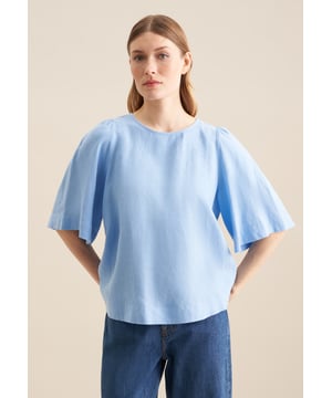 Feminin und elegant: Die Shirtbluse von Seidensticker aus der "The Connecting Neutrals" Kollektion erweitert Ihre Garderobe um ein vielseitig einsetzbares Kleidungsstück. Ob Freizeit oder Büro - sie ist ein eleganter Begleiter, der durch schlichte Eleganz überzeugt. Der mit hoher Dichte gewebte und damit besonders widerstandsfähige Leinen-Stoff ist aus 100% Leinen - ideal für pflegeleichte Outfits. Durch ihren Schnitt in Modern fit liegt die Shirtbluse nicht so eng und eher leger an und bietet so einen optimalen Komfort beim Tragen. Ein echter Hingucker, der sich als clevere Fusion aus klassischer Noblesse, im Zusammenspiel mit modernem Dessin präsentiert. An schönen warmen Tagen liegen Sie mit dieser Kurzarm-Shirtbluse stets goldrichtig. Dank dem Rundhals-Ausschnitt wird der smarte Charakter besonders betont. Zusätzlich sind edle Perlmuttknöpfe verarbeitet worden.