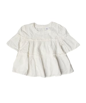 Top para niñas con un encantador diseño de volantes que añade un toque de estilo y movimiento.

Presenta un escote redondo que proporciona un ajuste cómodo y un acabado limpio en el cuello.

Las mangas cortas también están adornadas con volantes, añadiendo un toque femenino y divertido.

El cierre en la parte posterior del cuello facilita poner y quitar la prenda, lo que la convierte en una opción práctica para el uso diario o para ocasiones especiales.

Este top es ideal para combinar con faldas o pantalones, proporcionando un look elegante y versátil.  
Composición: 100% algodón  
Cuidado:  
- Lavar a mano o en ciclo delicado.  
- Utilizar detergentes suaves.  
- No usar secadora.  
- Planchar a baja temperatura.  
- No limpiar en seco.