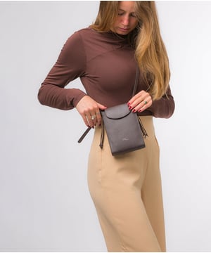 The 'Kiana' cross body phone bag from the Pure Luxuries Marylebone Collection is handcrafted from high-quality, genuine Nappa leather with a natural super-soft touch. The minimalistic fold-over top is secured by a gold-coloured magnetic press stud. This practical design is the perfect place to keep your phone safe and features a tassel design on the exterior. Lined with 100% cotton for a flawless finish and comes with a matching and adjustable slim leather strap with a maximum drop length of 65cm. The minimalist Pure Luxuries logo is embossed in gold foil for a beautifully simple finishing touch.