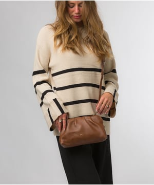 The 'Halsey' cross body clutch bag from Pure Luxuries London's Knightsbridge Collection is handcrafted from gold standard Nappa leather with a super-soft and smooth finish. The zip-over top opens to reveal a 100% cotton interior. The spacious compartment features four card slots to help maintain an organised bag. Comes with an adjustable and removable slim leather strap, with a maximum drop length of 65cm. Features gold-coloured metal fittings and zips. The minimalist Pure Luxuries logo is embossed in gold foil for a beautifully simple finishing touch.