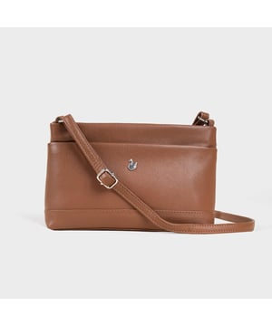 Redefine elegance with the ‘Sandra’ soft Nappa leather crossbody bag, a perfect fusion of luxury, craftsmanship, and practicality. Beautifully handcrafted from the finest full-grain soft Nappa leather, this multifunctional crossbody bag is designed for everyday use. Whether you're heading to work, a casual outing, or an evening event, the ‘Sandra’ crossbody bag is your go-to accessory for effortless sophistication and refined style. Premium Full-Grain Nappa Leather – Crafted from the softest and most supple genuine leather, offering a luxurious touch and exceptional durability. Smart & Functional Design – Smooth zippers open to a roomy main compartment for easy organisation and secure storage. Fully lined with fresh cream polyester fabric, allowing you to easily spot your essentials. Multipocket - Secured Front slip pocket and back zip pocket to slide in your essentials. Adjustable Leather Shoulder Strap – Designed for custom comfort, allowing you to adjust the length of the strap to suit your size. Lightweight & Versatile – A perfect everyday companion, seamlessly blending style and functionality. Signature Assots ‘Swan’ Collection – Embellished with the iconic ‘Swan’ logo, symbolising elegance, grace, and superior craftsmanship. Additional Internal Features - Zip pocket for car keys and house keys. Slip-in pocket for other essentials. Fittings Colour: Silver, Composition: Body: 100% Genuine Leather, Lining: Polyester. Size- W22cm x H16cm x D7cm.