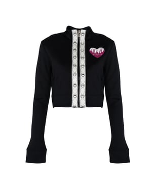 El corte más corto de esta blusa excepcional le da un aspecto moderno y dinámico, ideal para cualquier ocasión, desde encuentros casuales hasta salidas nocturnas.

Cierre con cremallera, lo que asegura comodidad y rapidez en el uso, además de añadir un carácter deportivo, mezclándose perfectamente con el resto de detalles.

Los puños elásticos no solo destacan el diseño elegante, sino que también proporcionan confort y protección contra el viento, lo que hace esta chaqueta una elección ideal para días más fríos.

Las bandas decorativas con elementos de marca añaden elegancia y carácter único, haciendo que sea un elemento inigualable en el guardarropa que seguramente atraerá miradas.

El parche en forma de corazón con el logo y elementos decorativos es un detalle sutil, pero sofisticado, que resalta el prestigio y la atención al detalle que ofrece esta blusa.

Fabricado en Italia, lo que garantiza la más alta calidad de fabricación y el uso de los mejores materiales, conocidos mundialmente por su excelente artesanía.