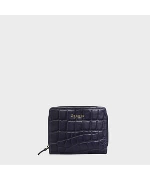 The 'Jolly' compact RFID equipped wallet purse is perfectly handcrafted with premium vintage Croc real leather for that designer look. This timeless design wallet purse easily fits in your bag or pocket featuring multiple card slots, slip pockets and a zip pocket. Organise your belongings with ease with 'Jolly' the perfect medium sized wallet purse.
Riveted closure for safe and secure storage. Zip compartment for you to store your coins and keys. Equipped with RFID technology to keep you safe from modern theft. Three card slots and three slip pockets for you to store your cards and notes. Compact size fitting easily in your bag or pocket. Fittings: Clean Brass. Composition: Body: 100% Genuine Leather. Lining: Polyester.
DISCLAIMER : All pictures shown are for illustration purpose only. Actual product colour may vary due to different ambience lighting or the screen display settings. Size- W11cm x H9.5cm x D2cm.