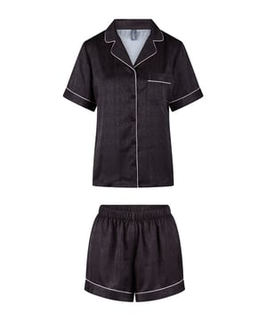 "Gift comfort. Gift luxury. Our Lounge Gift Set." Deze Shortama Set heeft een blouse met korte mouwen en een kort broekje in een mooie satijnen stof. Het bloesje heeft knoopsluitingen en een borstzakje aan de voorzijde. Op het borstzakje staat LD gestikt. Het broekje heeft een elastische tailleband. Feestelijk verpakt.
