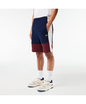 Lacoste Regular Fit Brushed Fleece Colourblock Jogger Shorts. Sporty colorblock shorts with a hip design and functional cut. Graphic style, soft texture. Urban pieces for contemporary looks, signed Lacoste.- Regular fit, straight cut.- Drawstring waist.- Side pockets.- Embroidered crocodile on front. Material: 80% Cotton, 20% Polyester. Ref: GH1319PIG.
