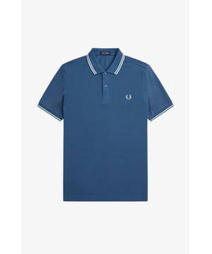 The Twin Tipped Fred Perry Shirt. Made from our classic cotton piqué, in a contemporary adaptation of Fred's famous streamlined fit. Available in a diverse range of colourways - each with their own unique story.
See the Read More section for this product’s key responsible features.
Cotton piqué / Regular fit / Slightly slimmer proportions than the original M12 / Twin tipped collar and cuffs / New two button set-in placket

Our twin tipped piqué shirt was the first to carry our legendary tipping in the 5-4-4 ratio, and it remains at the core of everything we do. An interpretation of our original Twin Tipped Fred Perry Shirt, the M3600 offers a more contemporary adaptation of Fred's famous streamlined fit, with a slightly closer fit. Manufactured on state of the art, modern technology and available in a huge range of colours - each with their own unique story to tell. It comes with a history, and each new generation adds to its legacy. Always different, always the same.
We're looking at ways to reduce our impact on the planet. This product is made with the following key responsible features:
Recycled Tipping & Sewing Threads
Buttons Made from Recycled Materials
Responsibly-Sourced Laurel Wreath Embroidery
To find out more, head to our Community page.
Fred Perry is a proud member of Better Cotton. By choosing our cotton products, you’re supporting Fred Perry's investment in Better Cotton’s mission.
100% Cotton
Machine Wash

Style
M3600
Colour
Midnight Blue