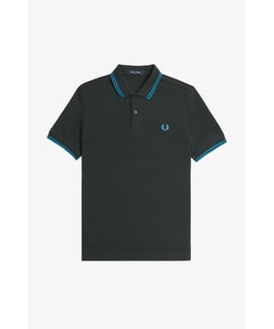The Twin Tipped Fred Perry Shirt. Made from our classic cotton piqué, in a contemporary adaptation of Fred's famous streamlined fit. Available in a diverse range of colourways - each with their own unique story.
See the Read More section for this product’s key responsible features.
Cotton piqué / Regular fit / Slightly slimmer proportions than the original M12 / Twin tipped collar and cuffs / New two button set-in placket

Our twin tipped piqué shirt was the first to carry our legendary tipping in the 5-4-4 ratio, and it remains at the core of everything we do. An interpretation of our original Twin Tipped Fred Perry Shirt, the M3600 offers a more contemporary adaptation of Fred's famous streamlined fit, with a slightly closer fit. Manufactured on state of the art, modern technology and available in a huge range of colours - each with their own unique story to tell. It comes with a history, and each new generation adds to its legacy. Always different, always the same.
We're looking at ways to reduce our impact on the planet. This product is made with the following key responsible features:
Recycled Tipping & Sewing Threads
Buttons Made from Recycled Materials
Responsibly-Sourced Laurel Wreath Embroidery
To find out more, head to our Community page.
Fred Perry is a proud member of Better Cotton. By choosing our cotton products, you’re supporting Fred Perry's investment in Better Cotton’s mission.
100% Cotton
Machine Wash

Style
M3600
Colour
Night Green/Runaway Bay Ocean/Runaway Bay Ocean