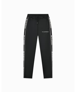 100% Poliéster Ajuste relajado Pantalones de chándal de pierna ancha Cintura elástica con cordón Dos bolsillos frontales Logo BLCK BNNS bordado en la pierna izquierda Cinta de marca bordada en los lados Se puede combinar con la Chaqueta de Chándal con Cinta