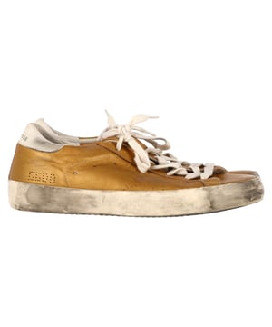 VINTAGE, UVP WIE NEU  
Fügen Sie Ihrer lässigen Garderobe mit den Golden Goose Superstar Perforated Sneakers aus goldenem Leder einen Hauch von Luxus hinzu. Diese Sneakers verbinden mühelosen Streetstyle mit hochwertiger Handwerkskunst und verfügen über ein perforiertes Design, das die Atmungsaktivität erhöht, sowie ein elegantes, metallisches Finish in Gold, das ein starkes Statement setzt. Die charakteristischen, abgenutzten Akzente verleihen ihnen einen coolen, eingetragenen Look, während die bequeme Sohle den ganzen Tag über Tragekomfort garantiert.  

Stil-Tipp: Diese vielseitigen Sneakers passen perfekt zu allem, von lässigen Jeans und einem T-Shirt bis hin zu einem schicken Midikleid für einen entspannten, aber stilvollen Kontrast. Für einen eleganten Streetstyle-Look kombinieren Sie sie mit Ledertrousers oder einer cropped Jeansjacke. Ob beim Erledigen von Besorgungen oder bei einem Kaffee-Date, die Golden Goose Superstar Sneakers verleihen jedem Outfit mühelos einen Hauch von Glamour.  

Golden Goose Superstar Perforated Sneakers aus goldenem Leder  

Zustand: Ausgezeichnet  
Tragespuren: Keine sichtbaren Gebrauchsspuren. Keine Markierung auf der Innensohle, sehr leichte Markierung an den Sohlen.  
Verpackung: Keine  
Farbe: Gold  
Material: Leder | Leder  
Größe: EU | 38  
Maße: Absatzhöhe: 30; Innensohlenlänge: 280  
SKU: NAPPUGBSH458415W