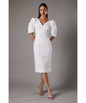 Exquisite floral lace pencil dress
        Striking pleated puff sleeves
        Elegant V-neckline at front and back
        Figure-hugging silhouette with midi length
        Subtle back slit for ease of movement
    
    Radiate sophistication in this stunning floral lace pencil dress from Coast. The intricate lace fabric creates a luxurious texture, while the pleated puff sleeves add a touch of drama and femininity. The V-neckline, both at the front and back, offers a graceful and alluring look. Perfect for formal occasions, this dress is ideal for weddings, race days, or any event where you want to make a lasting impression. Style it with strappy metallic heels and delicate drop earrings for a polished ensemble. For cooler evenings, drape a lightweight pashmina over your shoulders. This versatile piece can be dressed up or down, making it a valuable addition to your occasion wear wardrobe. The figure-hugging silhouette and midi length create a flattering shape, while the subtle back slit ensures comfort and ease of movement throughout your special event.