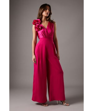 Striking corsage detail on one shoulder
        Elegant cowl back design
        Flattering V-neckline
        Wide-leg silhouette for a dramatic look
        Floor-sweeping length for added sophistication
    
    Make a lasting impression at your next formal event with this stunning Corsage Cowl Back Jumpsuit from Coast. The eye-catching corsage detail adorning one shoulder adds a touch of drama and femininity, while the elegant cowl back design introduces an element of allure. The wide-leg silhouette creates a flowing, statuesque effect, perfect for those seeking a chic alternative to a traditional gown. Style this jumpsuit with strappy metallic heels and a clutch bag for a refined ensemble suitable for weddings, race days, or black-tie affairs. For cooler evenings, drape a lightweight shawl over your shoulders to maintain an air of sophistication. This versatile piece can be dressed up or down, making it a valuable addition to your occasion wear wardrobe.