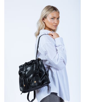 Bow Backpack in Black. Add a touch of charm with this silver bow backpack, featuring a convenient drawstring opening. Its stylish design offers both functionality and a playful accent, perfect for any casual outing. 
L:30cm W:10cm H:30cm
Colour: Black
SKU: HB350402
