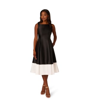 Crafted from luxurious mikado fabric for a structured yet graceful silhouette, this two-tone midi dress is a timeless look. This party dress features a chic boat neckline at the front and a flattering v-back, exuding timeless sophistication. The sleeveless design and colour block detail at the skirt hem add contemporary flair, while practical side pockets offer both style and functionality. Complete with a zipper closure at the centre back for a seamless fit, this cocktail dress is a versatile and elegant choice for any special occasion.