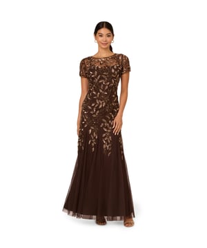 Our long and romantic gown dazzles with all-over handsewn beading in a feminine floral pattern that catches the light with every twirl. A streamlined silhouette is eased with the mermaid skirt with godets to create the right amount of movement. Our iconic and flattering no waist seam, sheer illusion yoke and cap sleeves. Sleek back zip closure.