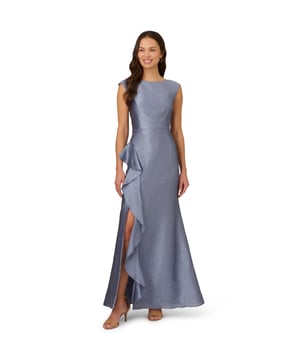 Expertly crafted with a textured jacquard fabric, this elegant sleeveless gown design creates a lustrous, shimmering finish. A fitted bodice with princess seams and a back zipper ensures a sleek mermaid silhouette. The high side slit adorned with ruffle accents offers comfortable wear and alluring movement. This opulent gown is perfect for your next formal event or special occasion.