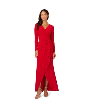 Slinky jersey fabric gives this long sleeve gown dramatic drape and exceptional comfort. A faux wrap construction gives the long dress design dynamic lines across the bodice and down the front of the flowing skirt. The back closes with a zipper and finishes with flattering ruching at the centre hip.