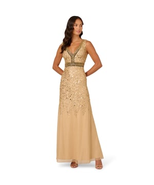 A metallic mesh overlay gives this full-length sleeveless dress its stunning shimmering look. Bead and sequin trim highlights the V-neck and V-back and wraps around the waist for extra definition. All over sequins over the shoulders trail down past the hips in a delicate scattered design. A back zipper closure finishes the dress to create a fitted silhouette.