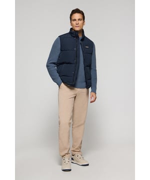 Gepolsterte Herrenweste ohne Kapuze. Kleiner Logo-Aufnäher in der Brust. Zwei Seitentaschen. Diese bequeme und praktische Weste ist ideal, um einen lässigen Look mit Jeans zu kreieren oder ein formelles Outfit mit Hemd und Chinos zu kombinieren.
