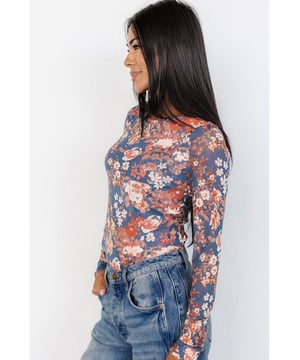 Elegantes Blumenmuster  
Atmungsaktives Mesh-Gewebe für Komfort und Stil  
Figurbetonte Silhouette, die schmeichelt  
Vielseitige lange Ärmel für den Einsatz in mehreren Jahreszeiten  
Perfekt zur Kombination mit Jeans oder Röcken  
Material: 95% Polyester, 5% Elasthan