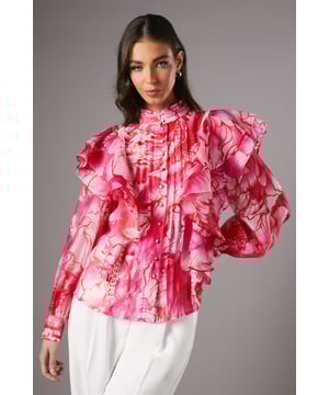 Chiffon blouse with eye-catching floral print
        Dramatic frill detailing along shoulders and sleeves
        Button-through front for adjustable styling
        High neckline with delicate ruffle trim
        Long sleeves with elasticated cuffs for a billowing effect
    
    Make a statement at your next special occasion with this striking frill button-through blouse from Coast. The bold floral print and voluminous ruffles create a captivating silhouette that's sure to turn heads. Perfect for weddings, race days, or formal events, this blouse can be styled in various ways to suit your personal taste. Pair it with crisp white trousers and matching heels for a sophisticated ensemble, or tuck it into a sleek pencil skirt for a more streamlined look. The versatile design allows for both daytime elegance and evening glamour. The lightweight chiffon fabric ensures comfort throughout your event, while the button-through front offers adaptable coverage. Accessorise with delicate jewellery to complement the blouse's intricate details and create a truly unforgettable outfit that embodies Coast's signature sophistication.
