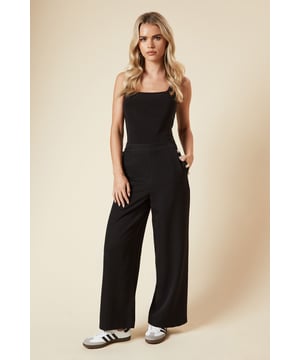 Tailored wide-leg design for a sophisticated silhouette
        Decorative button detailing on the waistband for added interest
        High-waisted fit to elongate the legs
        Smooth woven fabric with a touch of stretch for comfort
        Versatile length suitable for various shoe choices
    
    Make a statement with these petite tailored wide-leg trousers from Dorothy Perkins. Perfect for the fashion-forward woman in her 30s who values both style and comfort, these trousers offer a contemporary twist on a classic silhouette. The high waist and wide leg create a flattering, lengthening effect, while the button detailing adds a touch of sophistication. Ideal for smart-casual events, these trousers can be dressed up or down with ease. Pair with a crisp blouse and heels for a polished office look, or style with a fitted top and trainers for a chic brunch ensemble. The versatile design makes these trousers a go-to choice for various occasions, from baby showers to after-work drinks. With their blend of on-trend design and practicality, these trousers are sure to become a staple in your wardrobe, offering endless styling possibilities for the modern, busy woman.