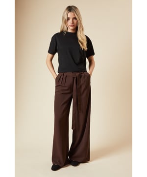 Wide leg silhouette for a relaxed, comfortable fit
        Pleated front detail adds texture and sophistication
        Belted waist for a customisable and flattering look
        Side pockets for practicality and style
        High-waisted design elongates the legs
    
    These pleated belted wide leg trousers from Dorothy Perkins are the epitome of effortless chic. Perfect for the fashion-forward woman in her 30s who values both style and comfort, these trousers offer versatility for various daytime occasions. Pair them with a simple t-shirt and trainers for a casual brunch with friends, or dress them up with a blouse and flats for a baby shower. The wide leg cut provides ample movement, while the pleated front and belted waist add a touch of sophistication. The high-waisted design flatters the figure and pairs beautifully with cropped tops or tucked-in blouses. These trousers are ideal for those who prefer a modest yet trendy look, offering coverage without compromising on style. Whether you're running errands or attending a family gathering, these trousers will keep you looking polished and feeling comfortable all day long.