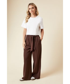 Chic paperbag waist design with removable belt
        Flattering wide-leg silhouette
        Convenient side pockets
        High-rise fit for a lengthening effect
        Versatile woven fabric for all-day comfort
    
    Embrace effortless style with these petite paperbag wide-leg trousers from Dorothy Perkins. Perfect for the fashion-forward woman who values both comfort and trend-setting looks, these trousers offer a versatile addition to your wardrobe. The high-rise paperbag waist, accentuated by a removable belt, creates a flattering silhouette that's ideal for various body types. Style these trousers with a crisp white t-shirt and trainers for a casual brunch with friends, or dress them up with a fitted blouse and block heels for a baby shower. The wide-leg cut provides a breezy, relaxed feel, making them suitable for family gatherings or casual office days. With their adaptable design, these trousers will quickly become a go-to piece for the modern woman who loves to look polished without compromising on comfort.