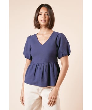 Charming puff sleeves for a feminine touch
        Flattering V-neckline enhances the dcolletage
        Tie-back detail adds a playful and adjustable fit
        Peplum-style waist creates a lovely silhouette
        Versatile cotton-linen blend for comfort and style
    
    This delightful tie-back puff sleeve blouse from Dorothy Perkins is the perfect addition to your wardrobe for those who appreciate a blend of trend and modesty. The puff sleeves and peplum waist create a charming silhouette, while the V-neckline offers a subtle allure. Ideal for casual outings, this blouse pairs beautifully with wide-leg trousers and sandals for a chic brunch ensemble. The tie-back detail allows for a customised fit, making it suitable for various body types. For family gatherings or baby showers, style it with tailored trousers and low heels for a polished look. The cotton-linen blend ensures breathability and comfort, making it a go-to piece for warm weather events. This versatile top can easily transition from day to night, simply swap your flats for a pair of statement earrings and you're ready for an evening out with friends.