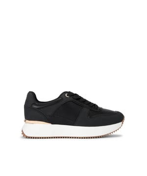 This KG Kurt Geiger London sneaker is a chunky style shoe crafted in black. The front laces up and there is a gold tone panel around the back of the ankle.