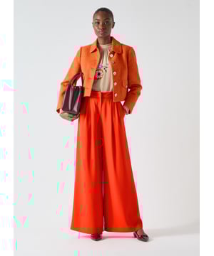 Embrace warmth and sophistication with the Vita collar cotton tweed jacket. This cropped jacket, crafted from Italian cotton in vibrant orange, boasts gold metal buttons and full length sleeves. Ideal for lunch dates or business meetings, pair it with tailored trousers or a pencil skirt for a stylish, polished look.