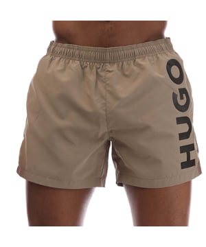 Mens HUGO Abas Logo Print Swim Shorts in beige.- Elasticated drawstring waistband.- Side pockets.- Back pocket.- Printed HUGO logo.- 100% Polyester (Recycled).- Ref: 50513979219