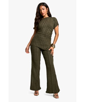 Textured jersey fabric with crinkle effect
        Draped design for a flattering silhouette
        Coordinated top and flared trousers set
        Short sleeves and round neckline on top
        High-waisted flared trousers for elongated look
    
    Make a statement with this eye-catching petite co-ord set, perfect for your next night out. The textured jersey fabric adds depth and interest, while the draped design of the top creates a figure-flattering silhouette. Pair with strappy heels and statement jewellery for a head-turning ensemble that's sure to impress. The high-waisted flared trousers elongate your legs, making this set ideal for dancing the night away at the club or enjoying drinks with friends. Versatile enough to dress up or down, this co-ord can take you from casual meetups to more formal evening events with ease. The crinkle effect adds a touch of edgy sophistication, ensuring you stand out in any crowd.
