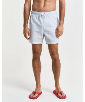  
 Crafted from 100% recycled polyester, these GANT swim shorts are essential for the summer season. Detailed with an all-over seersucker pattern and cut for a regular fit, they have a mid-thigh length and a regular waist. They feature an embroidered GANT shield on the left leg, side seam pockets, a single back pocket, and an elasticated drawstring waistband. This product is made with recycled polyester.

Regular fit
Mid-thigh length
Regular waist
GANT graphic embroidered on left leg

 85% Recycled Polyester, 15% Cotton 

922516001
 