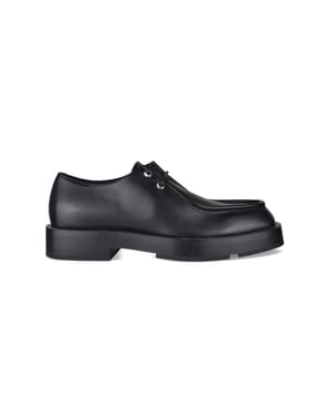 Derbies Givenchy Squared en piel lisa negra.Cierre de cordones negro.Logotipo monograma en relieve en la lengüeta. Puntera cuadrada.Suela gruesa de cuero con logotipo de metal plateado en la parte trasera.Made in Italy.