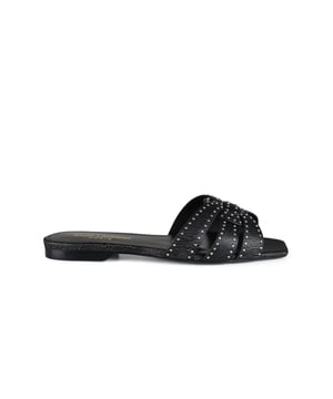 Mules Tribute Saint Laurent de piel negra. Adornada con tachuelas plateadas en los tirantes.Correas entrelazadas que forman el motivo de la firma Tribute.Puntera cuadrada abierta.Suela de cuero.Made in Italy.