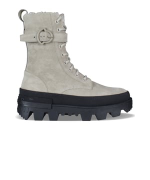 Moncler-laarzen, Carinne-model in beige suède.Enkelriempje.Voering van imitatiebont.Vetersluiting.Strapje op de hiel met Moncler-opschrift.Zwarte ingekeepte zool met rubberen logo.100% leer.Gemaakt in Italië.
