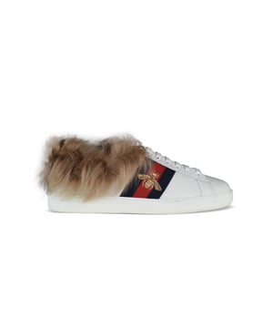 Gucci  ACE  witte leren sneakers.Donkerblauwe en rode stoffen strepen.Geborduurde gouden bij op buitenste banden.Witte toonbank met heldere elektrisch blauwe streep.Lamsvacht aan de binnenkant van de zool en rond de toonbank.100% leer.Gemaakt in Italië.