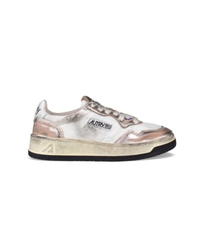 Sneakers bajas Autry super vintage.En piel laminada rosa viejo y lona blanca. Efecto desgastado.Detalles de cuero morado.Parche del logotipo en el exterior.Contrafuerte de cuero blanco agrietado y logotipo en relieve.Lengüeta con parche del logotipo.Suela de caucho efecto vintage amarillento. Cierre de cordones planos de color beige. Puntera redonda perforada.100% piel.