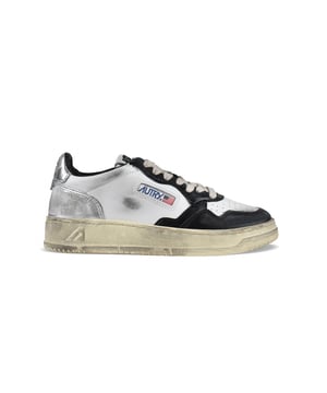 Sneakers bajas Autry Super vintage en piel blanca/negra/plateada.Inserciones de piel y efecto desgastado.Parche del logotipo en el exterior. Contrafuerte de piel plateada con logotipo en relieve.Lengüeta con parche del logotipo.Suela de goma efecto vintage en contraste. Cierre con cordones. Puntera redonda perforada.100% piel.