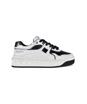 One Stud XL Sneakers von Valentino Garavani aus weißem und schwarzem Leder.Schwarze Maxi Niete mit glänzendem Finish.Schwarzer Druck des Valentino Garavani Logos auf der Außenseite.Dicker Schnürverschluss in Schwarz und Silber.Fersenkappe aus schwarzem Metallic-Leder.Innensohle aus Leder.Gummiaußensohle mit Nietendetails.100% Kalbsleder.Made in Italy.