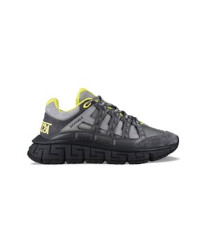 Sneakers Trigeca Versace en piel gris con detalles amarillos.Cierre de cordones grises y negros con cordones amarillos.Tejido gris.Inserciones bimateria.Logotipo Trigeca en la parte trasera amarillo.Suela Greca de goma negra.Logotipo en relieve en la suela.Made in Italy.