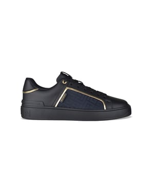 Balmain B-court sneakers van zwart leer.Nylon inzetstukken met logo met monogram aan de zijkanten.Zwart label met gouden logo op de zichtbare zijkant.Tong met logopatch van zwart en goud leer.Zwart lederen toonbank met gouden logo.Contrasterende gouden details.Zwarte vetersluiting.Zwarte rubberen zool met toon-op-toon logo op de hiel.Gemaakt in Italië.