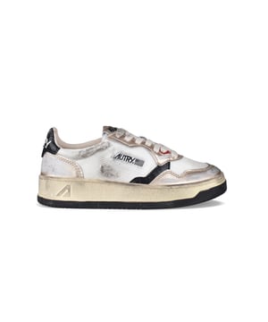 Sneakers bajas Autry super vintage.En piel laminada oro rosa y lona blanca. Inserción de cuero negro.Parche del logotipo en el exterior.Contrafuerte del talón de cuero negro agrietado y logotipo blanco en relieve.Lengüeta con parche del logotipo.Suela de caucho con efecto vintage amarillento. Cierre de cordones planos de color beige.Puntera redonda perforada.Efecto desgastado.100% piel.