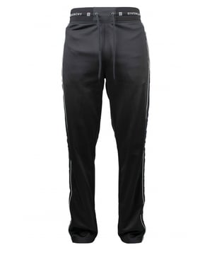 Un jogging de Givenchy.Franja lateral de terciopelo negro con línea blanca. Cordón de ajuste en la cintura.Logotipo blanco de Givenchy en la cintura. Dos bolsillos con cremallera. Cintura recta.Interior de vellón. 100% polyester.Made in Italy.