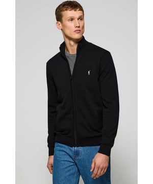 Unser Herren-Cardigan mit Reißverschluss ist der Inbegriff von Qualität und Stil. Aus Trikot-Baumwolle gefertigt, verfügt er bei geschlossenem Reißverschluss über einen hohen Kragen, der einen eleganten, modernen Look erzeugt. Die gerippten Details an Kragen, Ärmeln und Taille sorgen für einen perfekten Sitz und eine feine Passform. Seine zwei Seitentaschen bieten Komfort und Funktionalität. Das dezente Nahtband am marineblauen Kragen mit eingraviertem Polo Club-Logo unterstreicht die Eleganz dieses Cardigans. Charakteristische Stickerei unseres Rigby Go-Logos in Kontrastfarbe auf der Brust. Ein vielseitiges und stilvolles Kleidungsstück, das du mit Chinohosen oder Jeans kombinieren kannst.