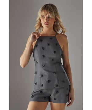 Elegant square neckline with thin straps for a feminine silhouette
        Delicate embellishment pattern scattered across the fabric for subtle sparkle
        Sleek, fitted design that contours to your shape
        Versatile woven fabric with slight stretch for comfort
        Coordinating shorts create a chic co-ord set perfect for evening occasions
    
    This embellished square neck top from Warehouse delivers confident sophistication with its contemporary design. The striking square neckline frames your dcolletage beautifully, while the scattered embellishments catch the light as you move, adding dimension to your evening look. Style with the matching shorts as shown for a coordinated ensemble that commands attention, or pair with tailored trousers and strappy heels for more formal gatherings. Add statement earrings and a clutch bag to complete your night-out ensemble. The sleek silhouette works wonderfully for drinks with friends, club nights, or sophisticated bar hopping - anywhere you want to showcase your fashion-forward sensibility while maintaining an effortlessly chic appearance. Machine washable for practicality without compromising on style.