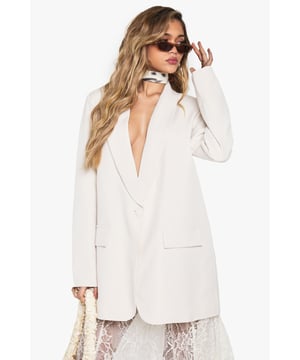 Oversized blazer with structured shoulder pads for a bold silhouette
        Deep plunging neckline creates a dramatic, contemporary look
        Relaxed fit design offers comfortable movement and versatile styling options
        Classic collared detail with notched lapels for timeless appeal
        Functional front pockets add practical detail to this statement piece
    
    Make a striking impression with this Boohoo oversized blazer, designed to command attention with its deep neckline and structured shoulder pads. The relaxed fit creates an effortlessly chic silhouette that works brilliantly for evening occasions. Style it as seen with a delicate lace skirt for an intriguing contrast between tailoring and femininity, or pair with slim-fit trousers and heels for a sophisticated night out look. For an edgier ensemble, throw it over a bodysuit with statement jewellery and your favourite clutch bag. This versatile blazer transitions seamlessly from drinks with friends to club nights, offering that perfect balance of comfort and head-turning style that's essential for your going-out wardrobe. Add sleek sunglasses and minimalist accessories to complete this contemporary urban nightlife look.