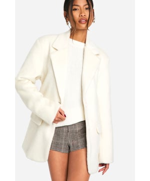 Chic belted coat with a wool-like texture
        Oversized lapels for a dramatic silhouette
        Long sleeves with turned-up cuffs
        Removable belt to cinch the waist
        Versatile length hitting mid-thigh
    
    Embrace sophistication with this stunning belted coat from Boohoo. The wool-like texture adds a touch of luxury to your ensemble, perfect for those chilly days when you want to look polished. The oversized lapels create a bold statement, while the removable belt allows you to customise your look. Style it over a crisp white shirt and tailored trousers for a refined office outfit, or throw it on over a little black dress for an evening out. For a more casual approach, pair it with your favourite jumper, jeans, and ankle boots. This coat is a versatile piece that will take you from day to night, adapting to various smart casual events with ease. Its timeless design ensures it will remain a staple in your wardrobe for seasons to come.